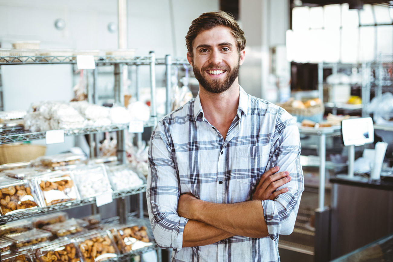 Male retailer smiling inside his business after posting a Texas sales tax bond