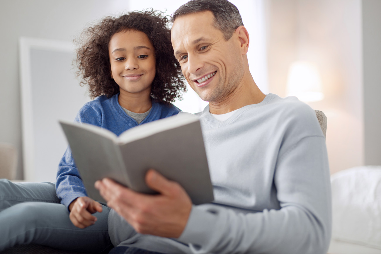 Young girl reading a book with her new guardian with a guardianship bond